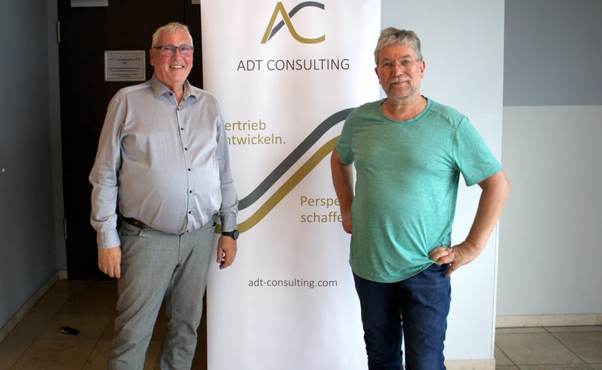Thomas Adt zusammen mit Jörg Kirsch vor dem Thomas-Adt-Werbebanner